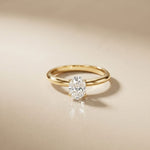 Gold ring with a diamond on a beige background Gold
