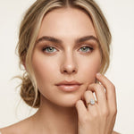 Woman wearing a diamond ring on a plain background Gold