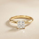 Gold ring with a diamond on a beige background Gold
