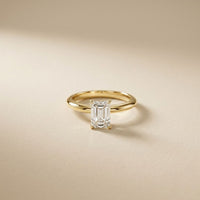 Gold ring with a diamond on a beige background Gold