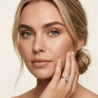 Woman wearing a diamond ring on a beige background White
