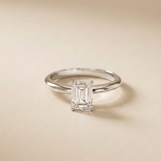 Diamond ring with emerald-cut gemstone on a beige background