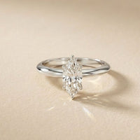 Silver ring with a diamond on a beige background White