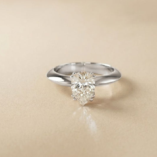 Silver ring with a diamond on a beige background