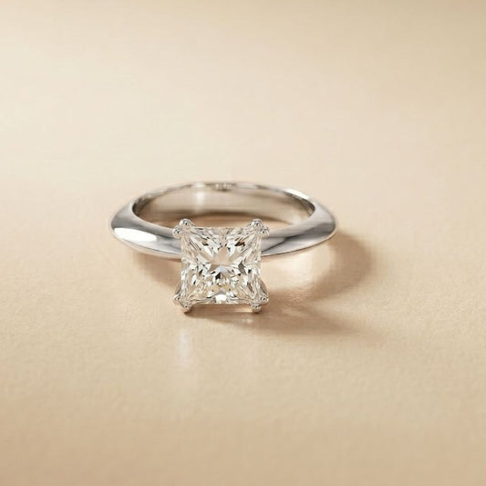 Silver ring with a diamond on a beige background