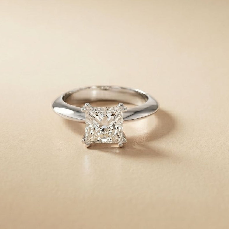 Silver ring with a diamond on a beige background White