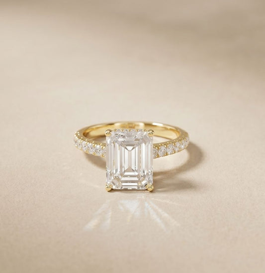 Gold ring with a large diamond and smaller diamonds on a beige background