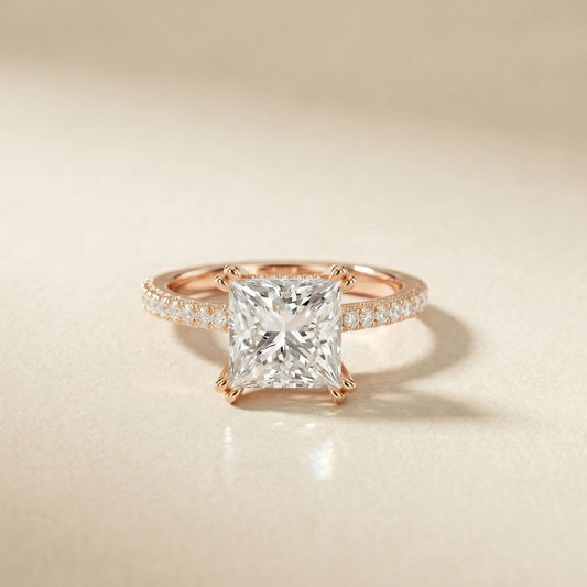 Rose gold ring with a large diamond and smaller diamonds on the band against a beige background